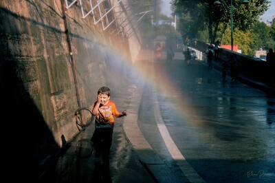 Un bambino corre sotto un arcobaleno a Parisplage, Parigi